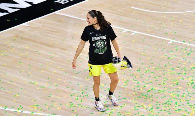 Sue Bird #10 of the Seattle Storm looks back while holding the WNBA Championship trophy...
