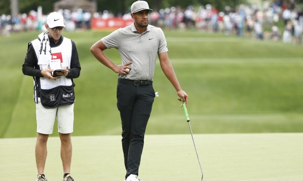 Tony Finau of the United States and his caddie wait on the 13th green during the second round of th...