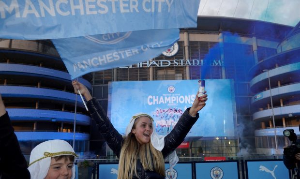 MANCHESTER, ENGLAND - MAY 11: Manchester City fans celebrate outside Etihad Stadium as their team h...