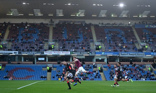 BURNLEY, ENGLAND - MAY 19: Chris Wood of Burnley runs with the ball as fans social distance in the ...