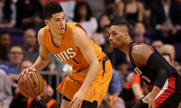 Devin Booker of the Phoenix Suns defended by Damian Lillard of the Portland Trail Blazers (Photo by...