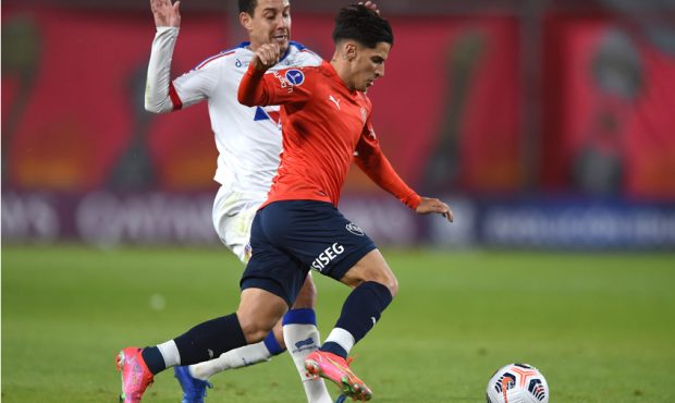 Rodriguinho of Bahia competes for the ball with Jonathan Menéndez of Independiente during a match ...