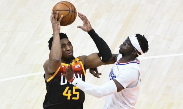 Utah Jazz guard Donovan Mitchell drives against Los Angeles Clippers guard Reggie Jackson (Photo by...