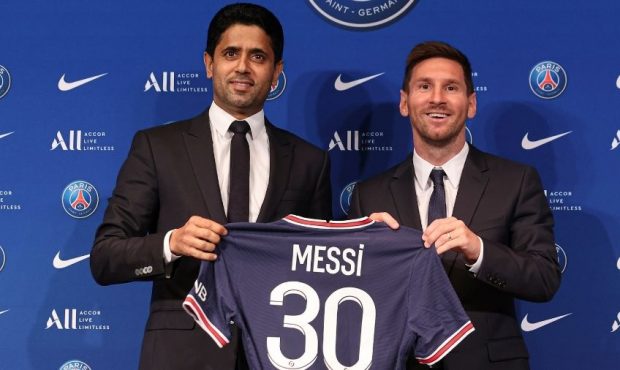 Lionel Messi poses with his jersey next to President Nasser Al Khelaifi after the press conference ...