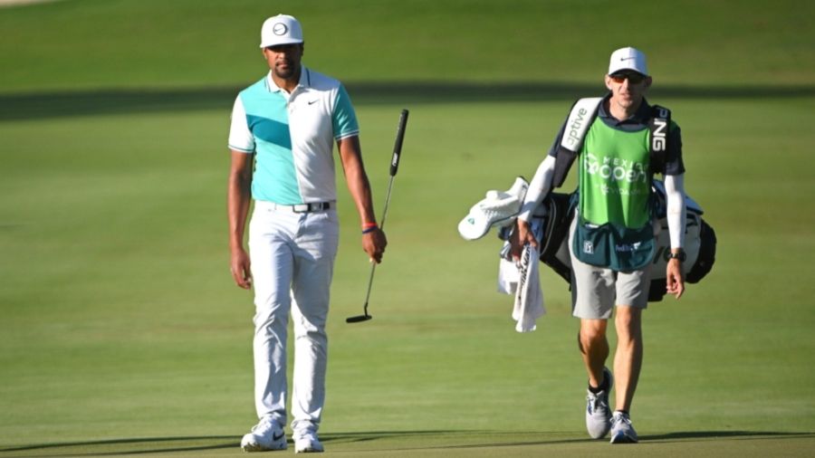 Tony Finau of United States and his caddie walk onto the 12th green during the second round of the ...