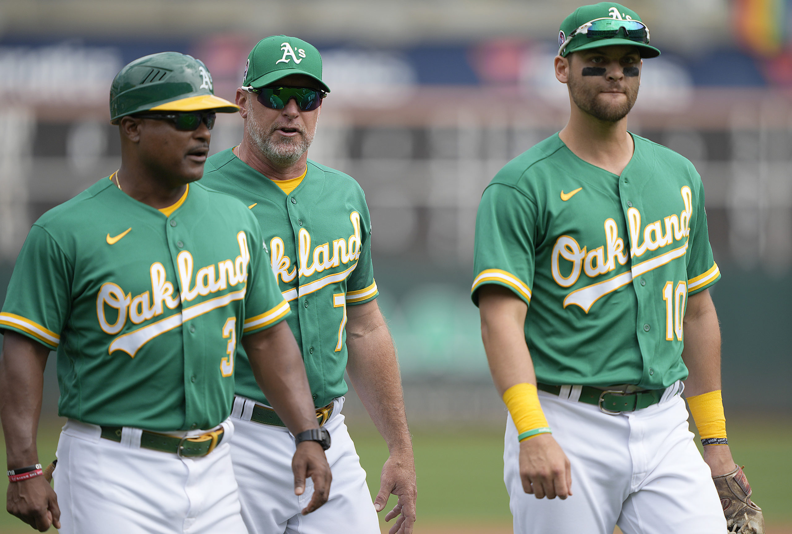 A's players walk on field with manager...