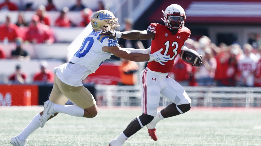 Nate Johnson #13 of the Utah Utes is chased by Kain Medrano #20 of the UCLA Bruins during the first...