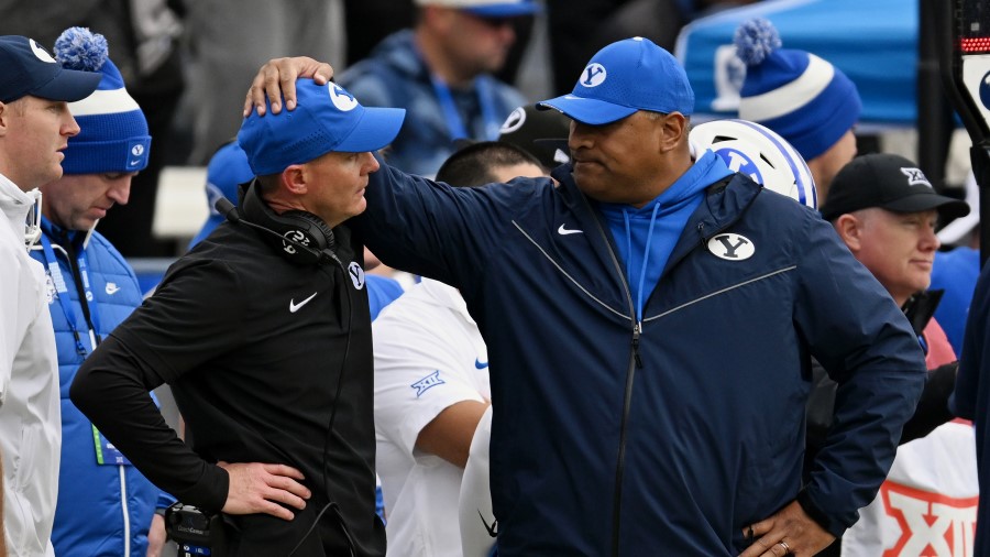 Brigham Young Cougars head coach Kalani Sitake puts his hand on associate head coach and defensive ...