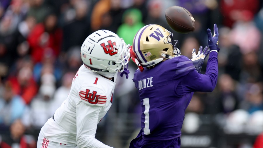 Rome Odunze #1 of the Washington Huskies catches a pass against Miles Battle #1 of the Utah Utes du...