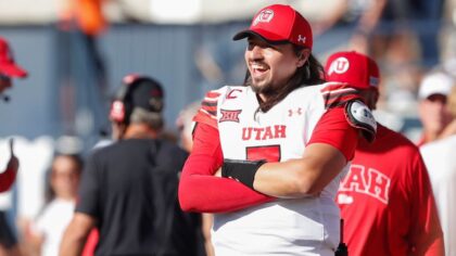 LOGAN, UT - SEPTEMBER 14: Cam Rising #7 of the Utah Utes smiles as he watches teammates celebrate a touchdown againsto the Utah State Aggies during the second half of their game at Maverik Stadium on September 14, 2024 in Logan, Utah. Rising is injured and did not play in the game. (Photo by Chris Gardner/Getty Images)