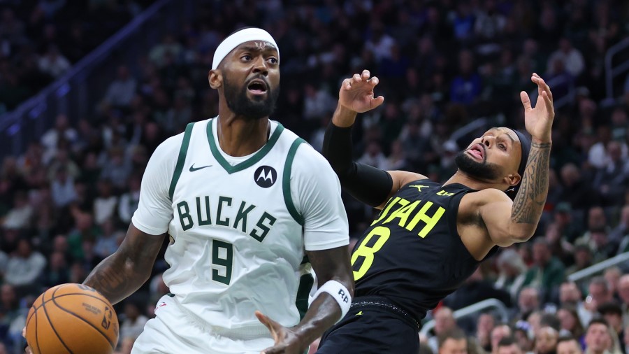 Bobby Portis #9 of the Milwaukee Bucks is defended by Patty Mills #8 of the Utah Jazz...